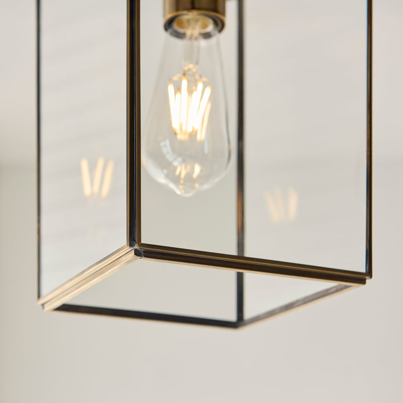 Hammond Lantern Pendant in aged brass shown in a room setting