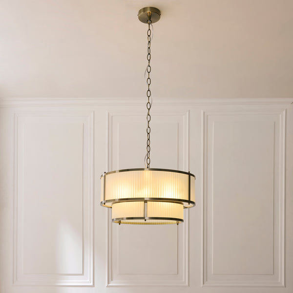 Ridgeton Frosted 5 Light Tiered Pendant lit up in a styled hallway