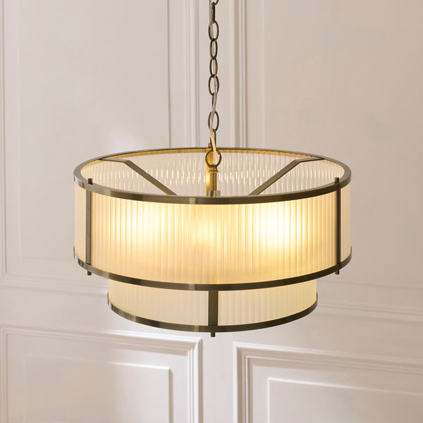 Ridgeton Frosted 5 Light Tiered Pendant in antique brass shown in a room setting