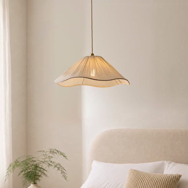 Isabella Pendant in brushed aged brass hanging in a bedroom