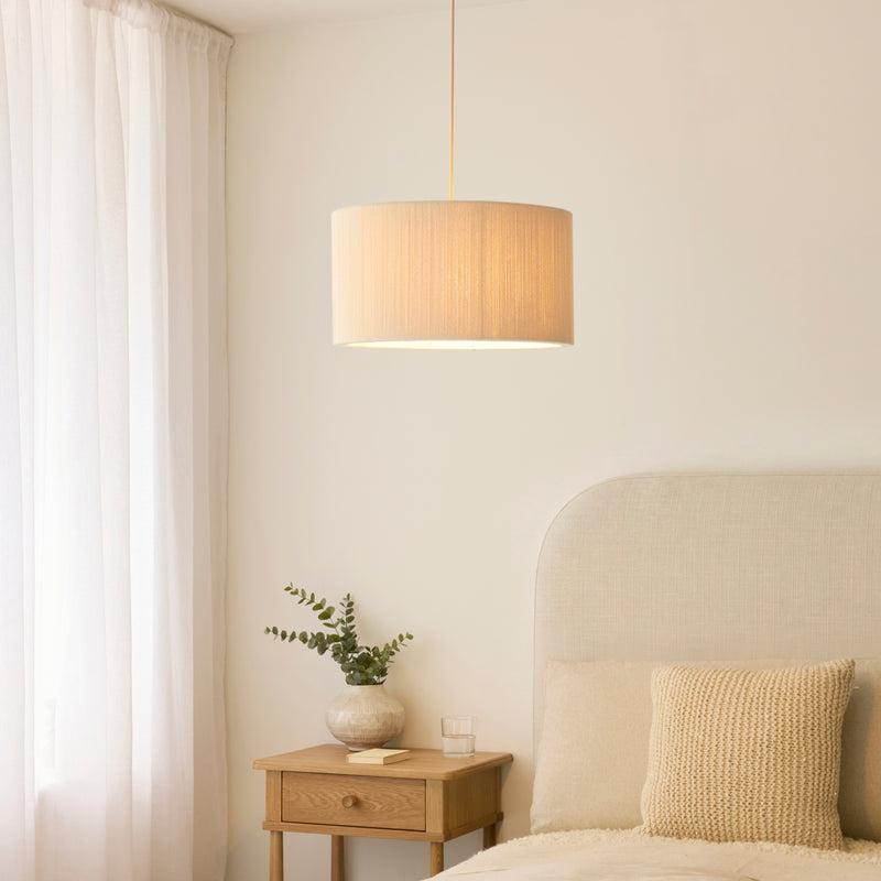 Noah Pendant in brushed brass and cream cotton hanging in a living room