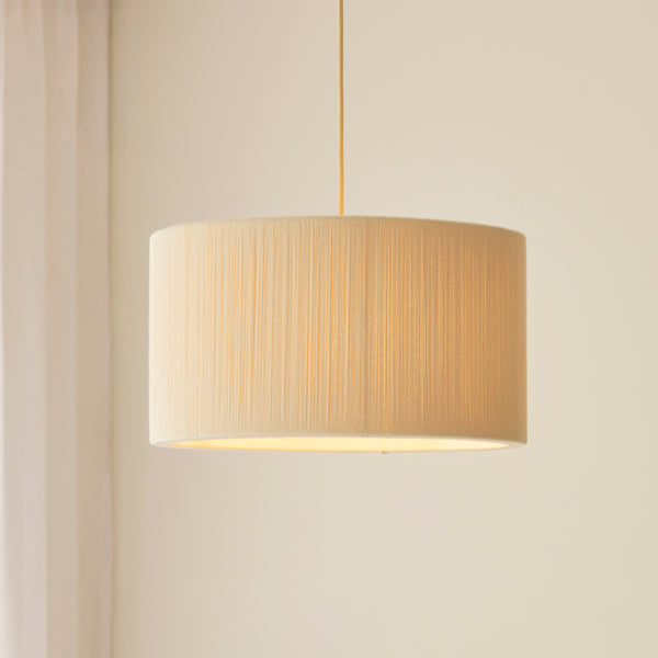 Noah Pendant in brushed brass and cream cotton shown in a room setting