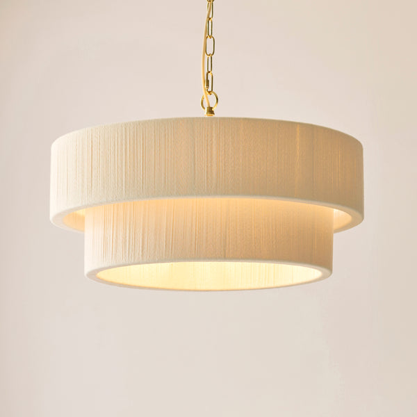 Noah 5 Light Tiered Pendant in brushed brass and cream cotton shown in a room setting