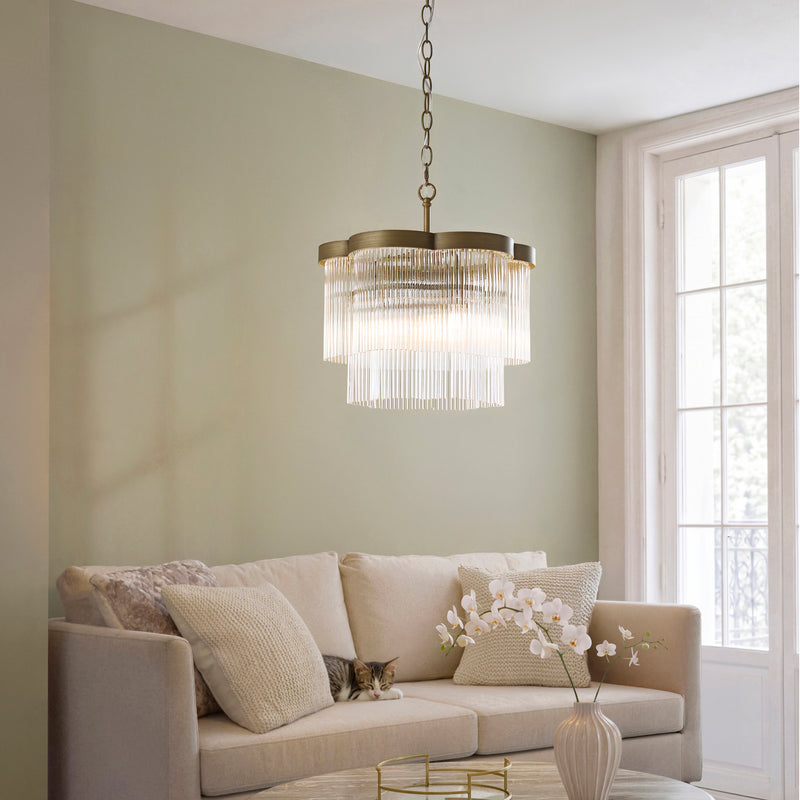 Lucille 3 Light Chandelier in antique brass hanging in a bedroom