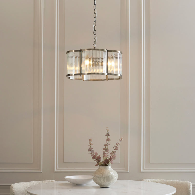 Ridgeton Scallop 3 Light Pendant in antique brass hanging in a hallway
