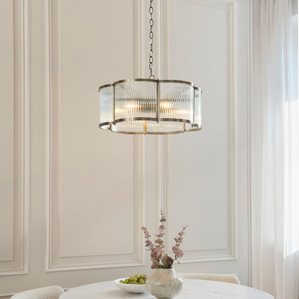 Ridgeton Scallop 5 Light Pendant in antique brass hanging in a living room