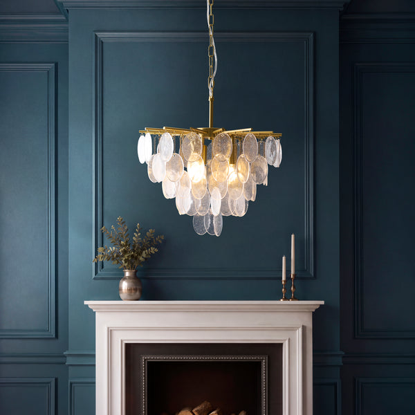 Loretta 3 Light Pendant in brushed aged brass hanging in a dining room