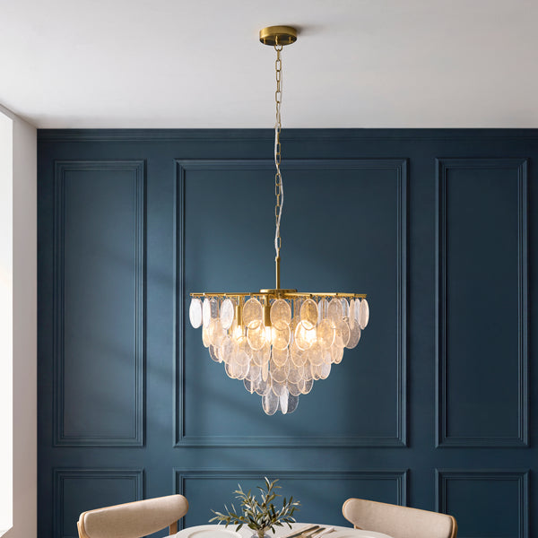 Loretta 5 Light Pendant in brushed aged brass hanging in a dining room