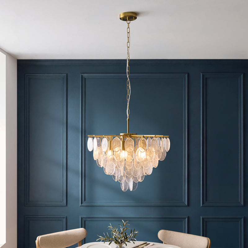 Loretta 5 Light Pendant in brushed aged brass hanging in a dining room