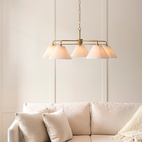 Wallbridge 5 Light Chandelier in brushed aged brass hanging in a living room