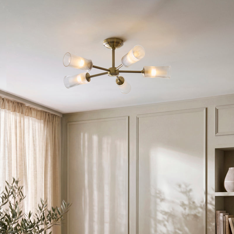 Avelyn 5 Light Semi Flush Ceiling Light in antique brass on a living room ceiling