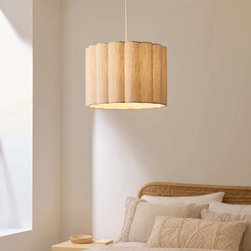 Olson Pendant in oak and natural fabric hanging in a bedroom
