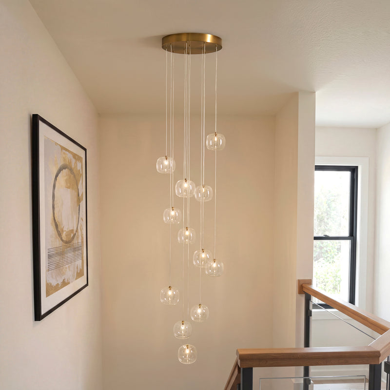 Oslo 12 Light Cascade Pendant in brushed aged brass hanging in a stairwell