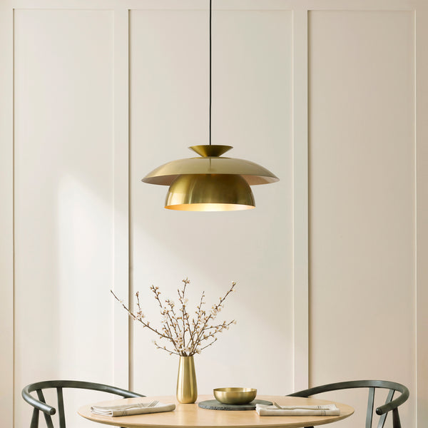 Lyon Pendant in satin brass hanging in a dining room
