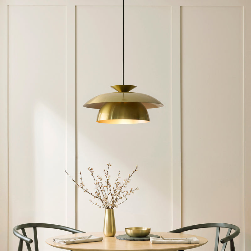 Lyon Pendant in satin brass hanging in a dining room