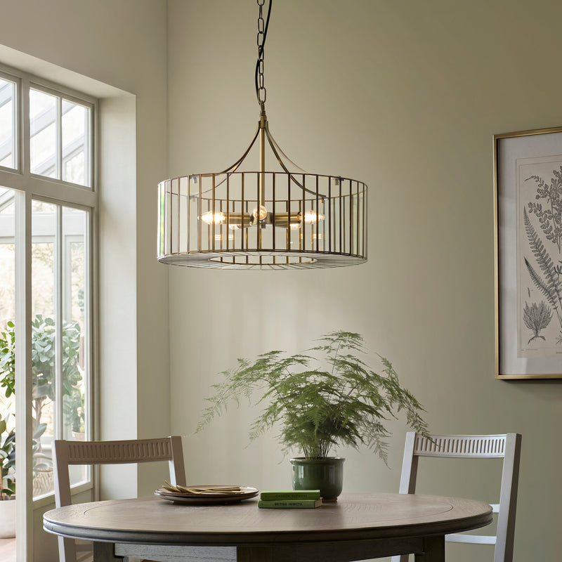 Antalya 5 Light Pendant in antique solid brass hanging in a dining room