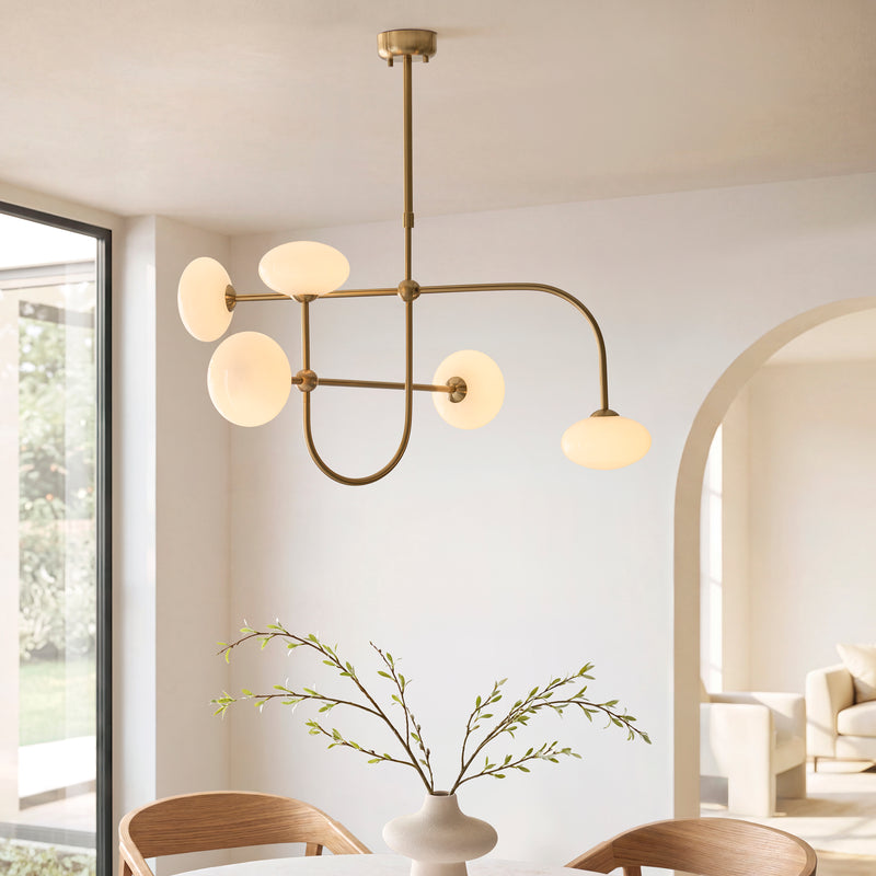 Ottowa 5 Light Pendant in brushed aged brass hanging in a living room