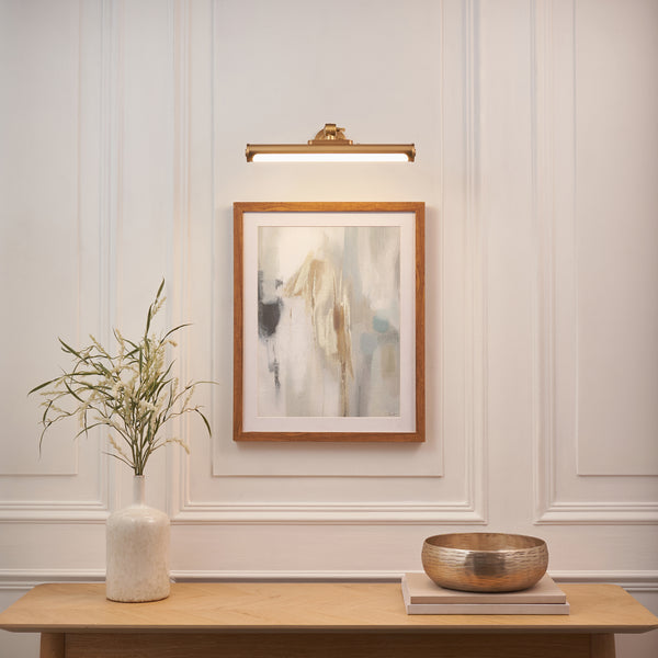 Kas Rechargeable Picture Light in warm brass on a wall