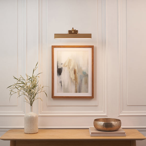 Lasos Rechargeable Picture Light in warm brass on a wall