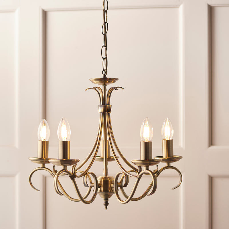 Bernice 5 Light Chandelier in antique brass hanging in a living room