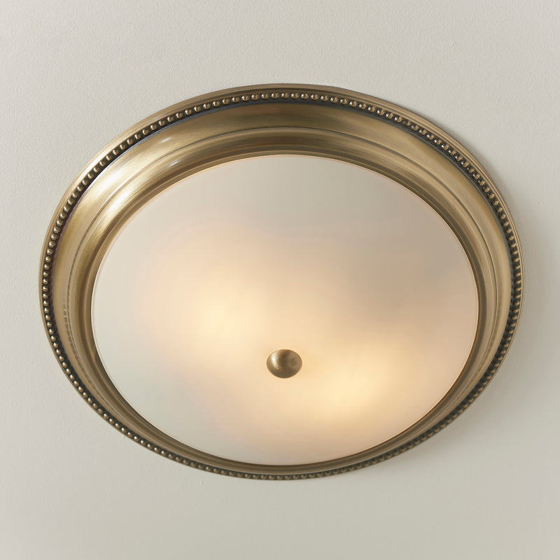 Atlas 2 Light Flush Ceiling Light in antique brass shown in a room setting