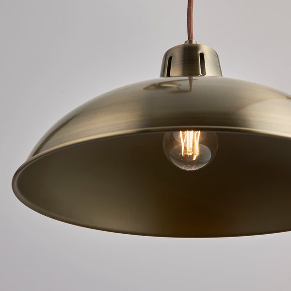 Polka Rise and Fall Pendant in antique brass shown in a room setting