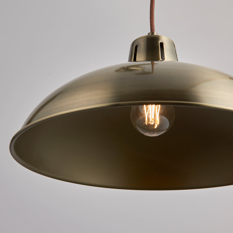 Polka Rise and Fall Pendant in antique brass shown in a room setting