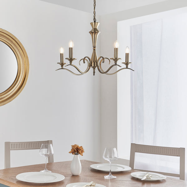 Kora 5 Light Chandelier in antique brass hanging in a living room