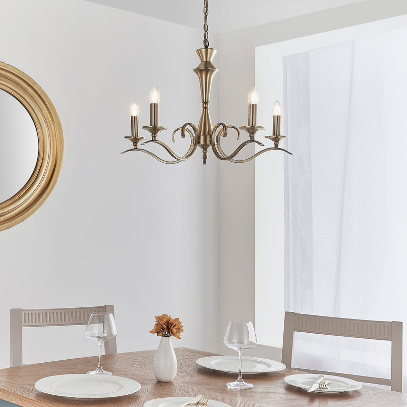Kora 5 Light Chandelier in antique brass hanging in a living room