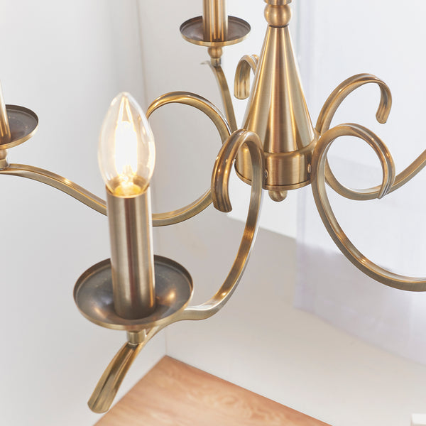 Kora 5 Light Chandelier in antique brass shown in a room setting