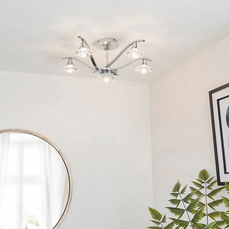 Langella 5 Light Crystal Semi Flush Ceiling Light lit up in a styled living room