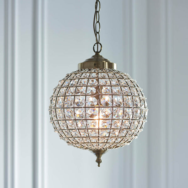 Tanaro Pendant in antique brass hanging in a hallway