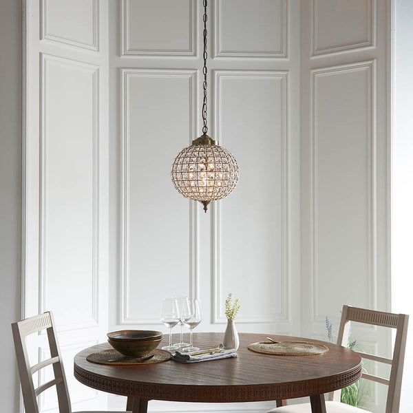 Tanaro Pendant in antique brass shown in a room setting