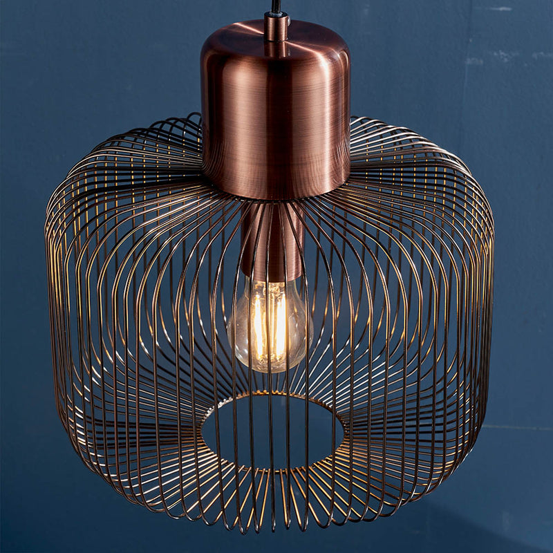 Nicola Cage Pendant in antique copper shown in a room setting