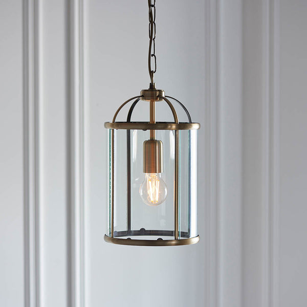 Lambeth Lantern Pendant in antique brass hanging in a hallway