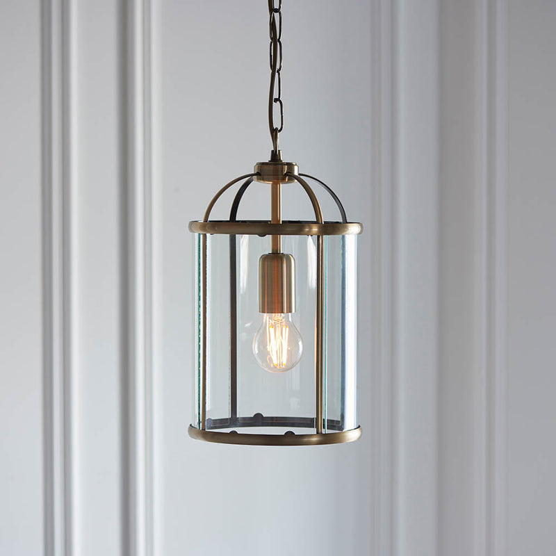Lambeth Lantern Pendant in antique brass hanging in a hallway