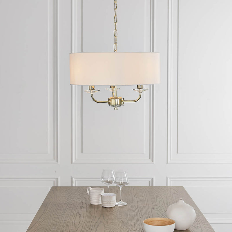 Nixon 3 Light Chandelier lit up in a styled bedroom