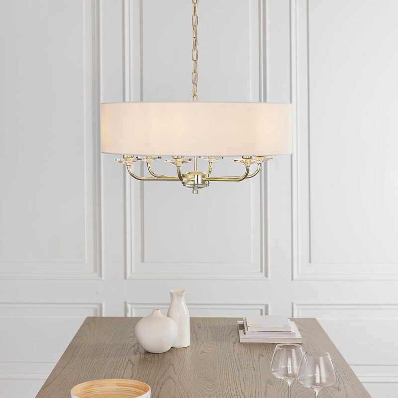 Nixon 6 Light Chandelier in brass hanging in a living room