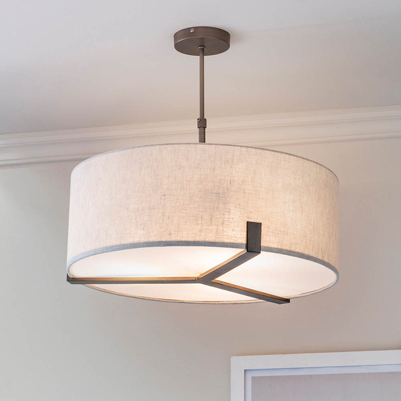 Hayfield 3 Light Drum Pendant in brushed bronze and linen hanging in a living room