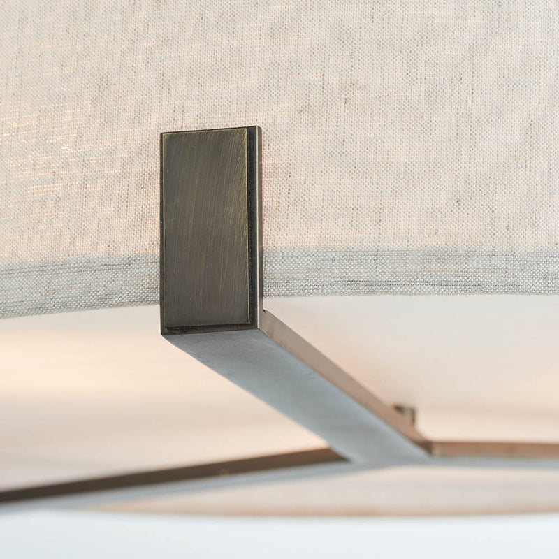 Hayfield 3 Light Drum Pendant lit up in a styled living room