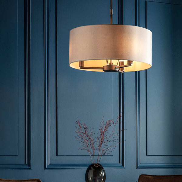 Daley 3 Light Drum Pendant in dark antique bronze hanging in a living room