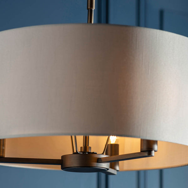 Daley 3 Light Drum Pendant lit up in a styled living room