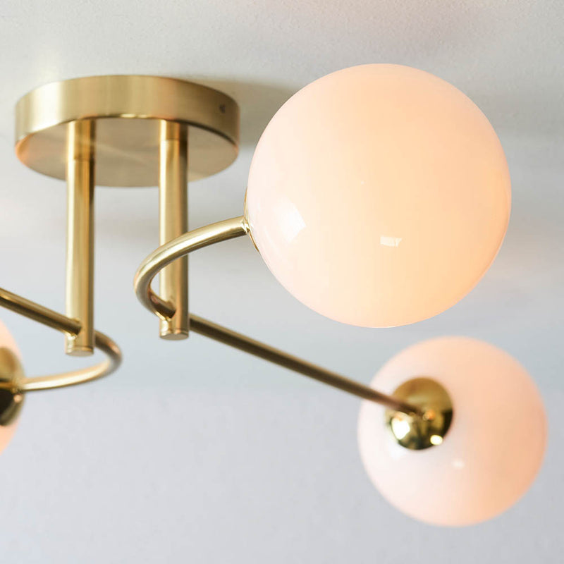 Otto 4 Light Semi Flush Ceiling Light lit up in a styled living room