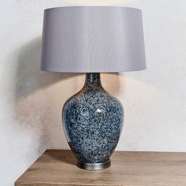 Ilsa Glass Table Lamp lit up in a living room setting
