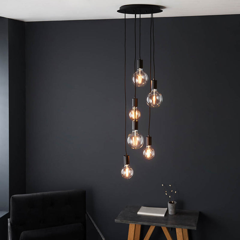 Studio 6 Light Cluster Pendant lit up in a styled dining room