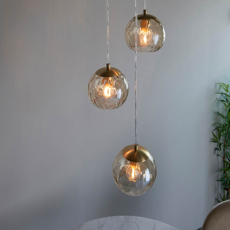 Dimple 3 Light Pendant in satin brass shown in a room setting