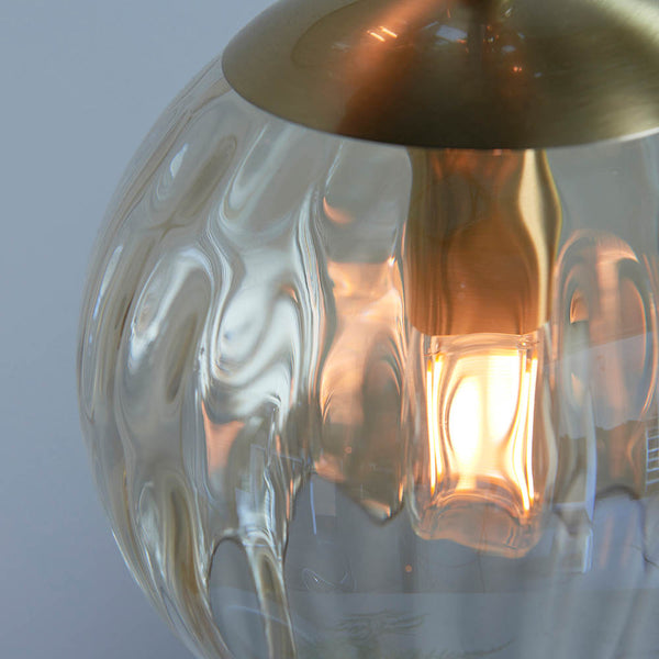 Close-up of the champagne lustre glass on the Dimple 3 Light Pendant