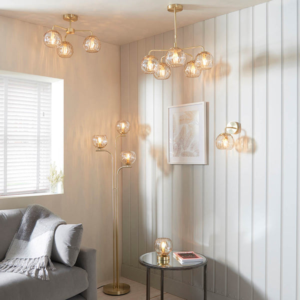 Dimple 3 Light Floor Lamp lit up in a living room setting