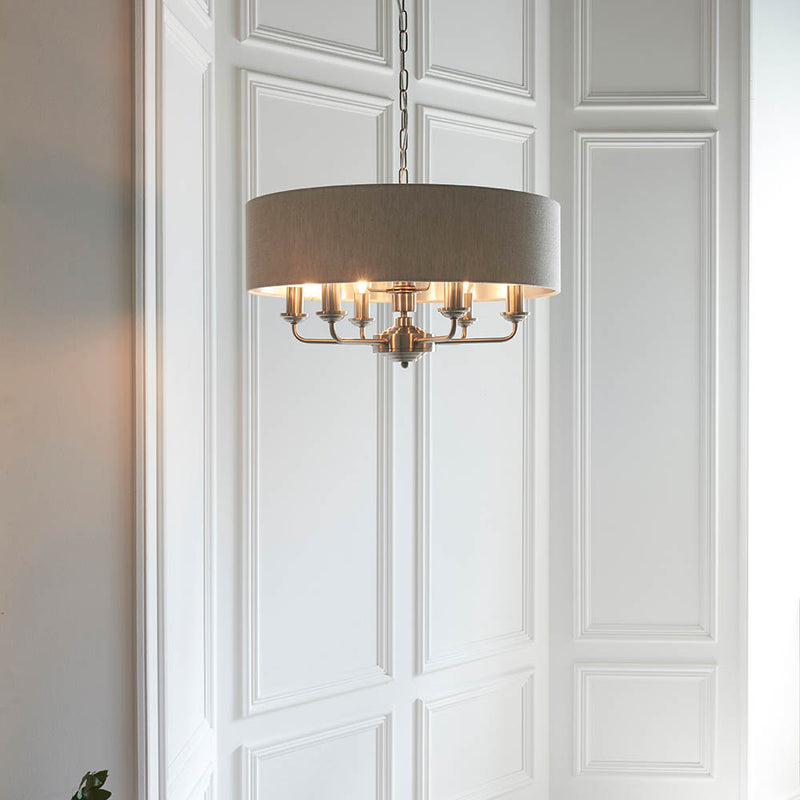 Highclere 6 Light Drum Pendant lit up in a styled living room