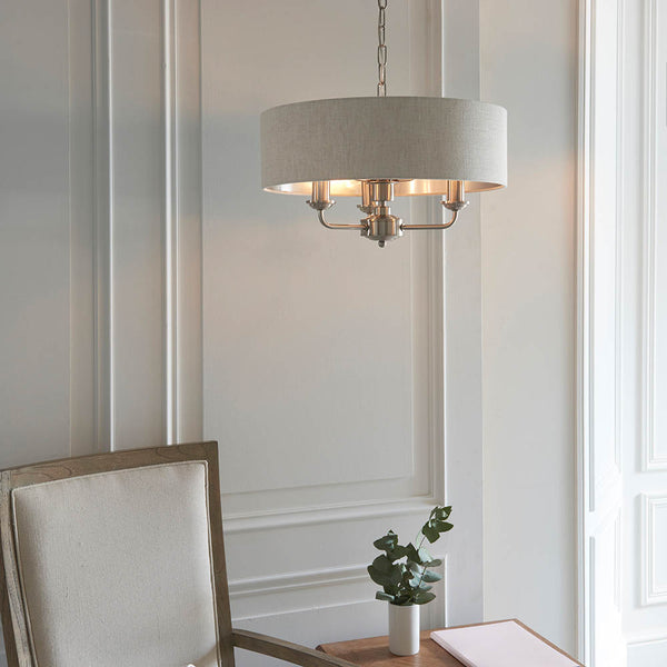Highclere 3 Light Drum Pendant lit up in a styled bedroom
